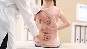 Child having spine examined.