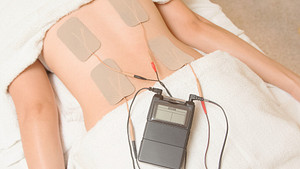 Tens unit being applied to the lower back.